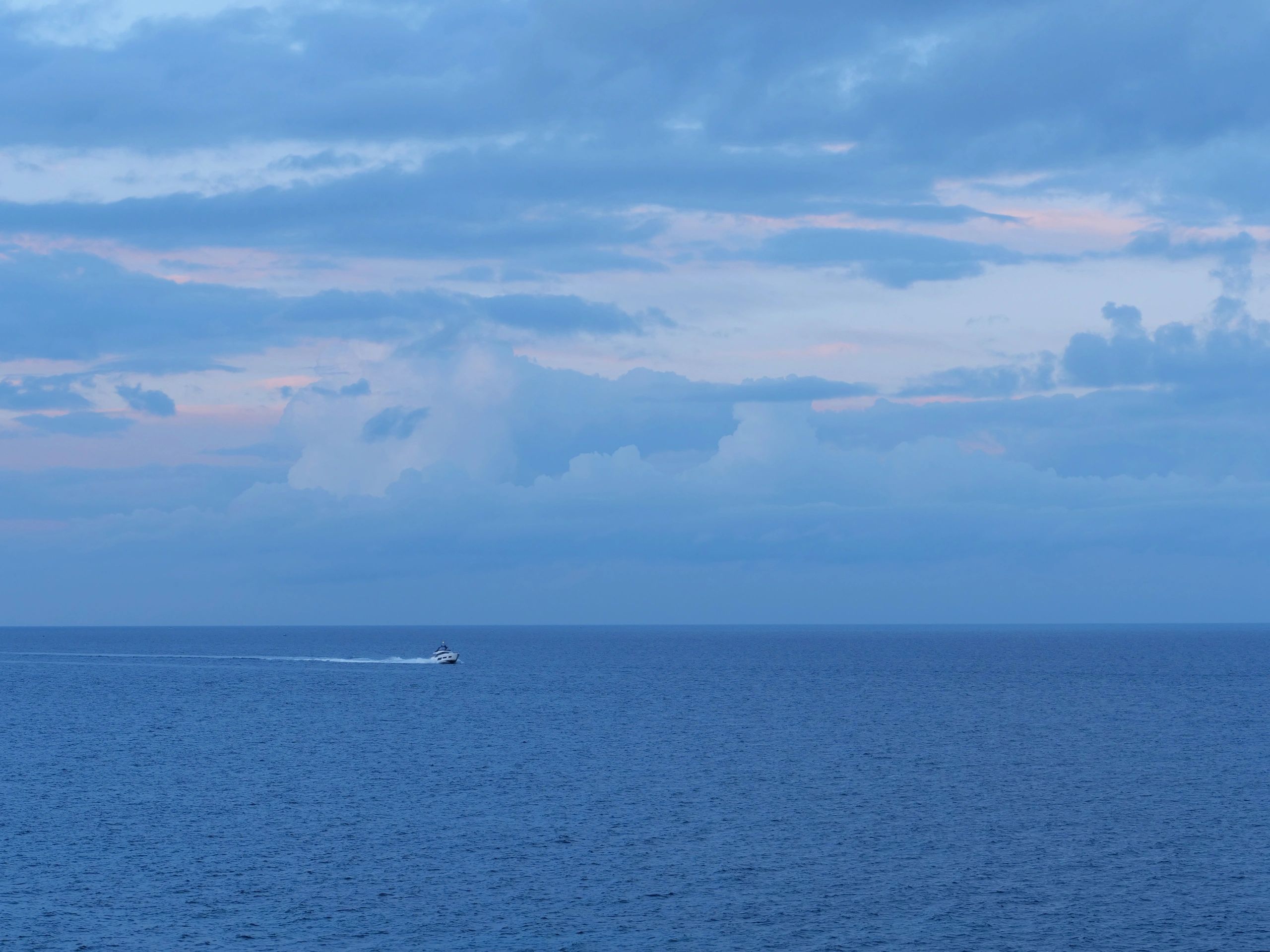 Boat traveling across open ocean leaving a wake
